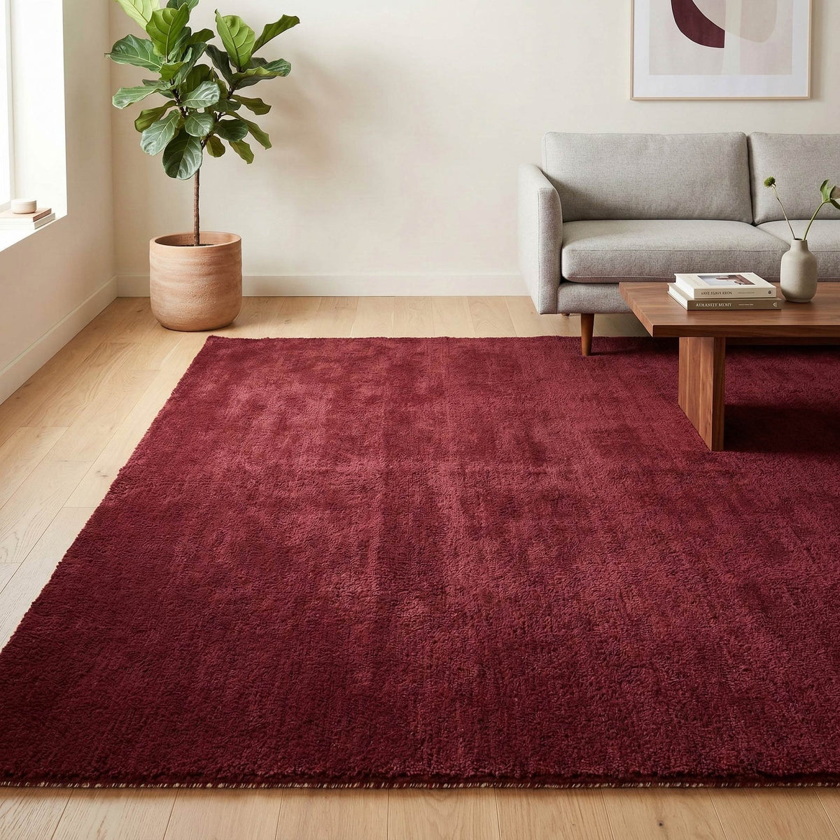 Plush solid burgundy hand-tufted wool rug showcasing a dense, luxurious cut pile texture on a clean white background.