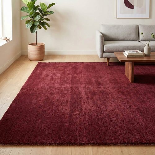 Plush solid burgundy hand-tufted wool rug showcasing a dense, luxurious cut pile texture on a clean white background.