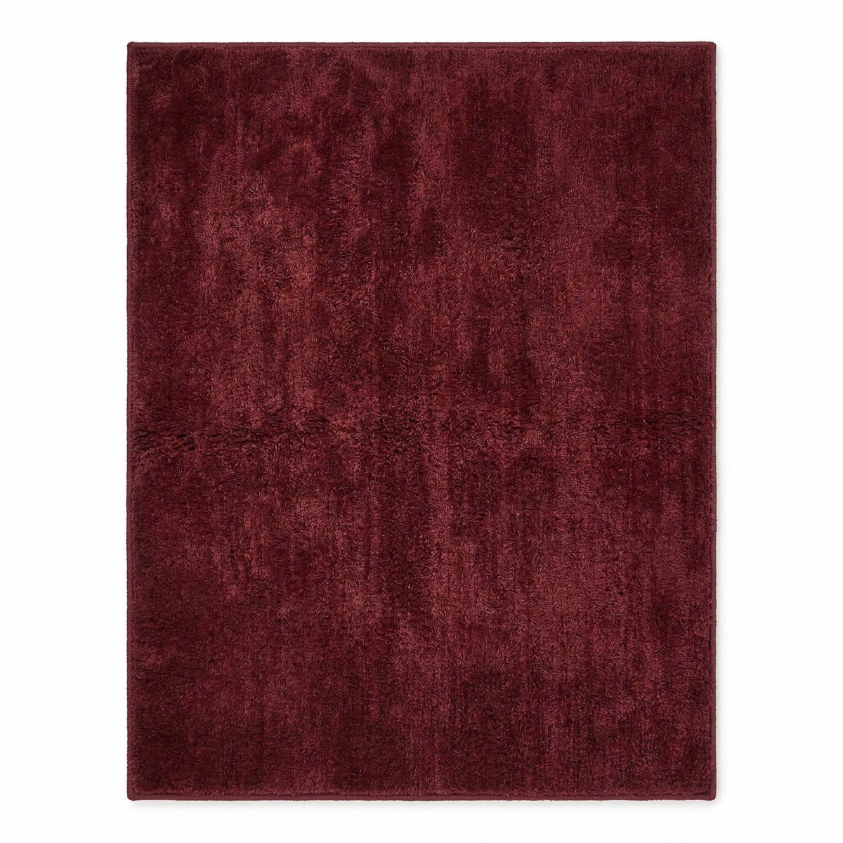 Plush solid burgundy hand-tufted wool rug showcasing a dense, luxurious cut pile texture on a clean white background.
