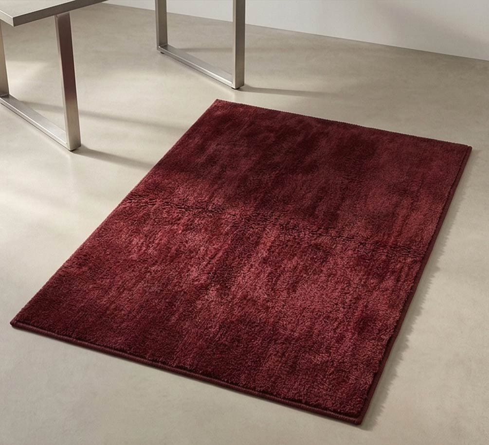Plush solid burgundy hand-tufted wool rug showcasing a dense, luxurious cut pile texture on a clean white background.